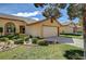 Tan house with a well-maintained lawn, mature landscaping, and a large garage at , Las Vegas, NV 89130
