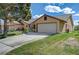 A tan house with a large garage, a well-maintained lawn, and mature landscaping at , Las Vegas, NV 89130