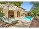 Beautiful backyard features a private pool, lounge chairs, and lush landscaping at 12277 Bluebird Canyon Pl, Las Vegas, NV 89138