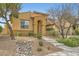 Charming single-story home with a two-car garage, landscaped front yard, desert rock and mature trees at 12277 Bluebird Canyon Pl, Las Vegas, NV 89138