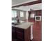 Open kitchen featuring granite countertops and dark wood cabinets flowing to the living area with a fireplace at 12277 Bluebird Canyon Pl, Las Vegas, NV 89138