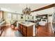 Open-concept kitchen with granite countertops, pot rack, stainless steel appliances, and hardwood floors at 12277 Bluebird Canyon Pl, Las Vegas, NV 89138