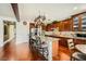Spacious kitchen featuring granite countertops, dark wood cabinets, an island, and hardwood flooring at 12277 Bluebird Canyon Pl, Las Vegas, NV 89138