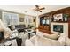 Inviting living room featuring a fireplace, a large leather sofa, a ceiling fan and wood floors at 12277 Bluebird Canyon Pl, Las Vegas, NV 89138