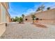 Desert landscaped backyard featuring decorative gravel, mature trees, and a view of the surrounding hillside at 1925 Hot Oak Ridge St, Las Vegas, NV 89134