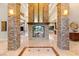 Grand foyer featuring stone columns, a fireplace, travertine floors, and an open floor plan at 23 Quiet Moon Ln, Las Vegas, NV 89135