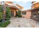 Elegant front entrance featuring stone accents, an outdoor fireplace, manicured landscaping, and custom iron doors at 23 Quiet Moon Ln, Las Vegas, NV 89135