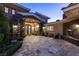 Stunning front entry with intricate iron doors, manicured landscaping, and a cozy sitting area at 23 Quiet Moon Ln, Las Vegas, NV 89135