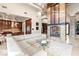 Open-concept living room showcasing a stone fireplace, modern furnishings, and a seamless flow into the kitchen at 23 Quiet Moon Ln, Las Vegas, NV 89135