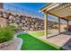 The backyard boasts a privacy wall, turf, brick patio, and pergola at 257 Via Franciosa Dr, Henderson, NV 89011