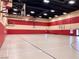 A gymnasium with a full-size basketball court, striped walls, and multiple hoops at 257 Via Franciosa Dr, Henderson, NV 89011
