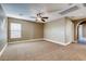Expansive carpeted bedroom with a ceiling fan, window, and doorway leading to another room at 257 Via Franciosa Dr, Henderson, NV 89011