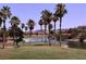 Scenic golf course with a lake, fountains, a horse sculpture and tall palm trees with beautiful homes in the background at 257 Via Franciosa Dr, Henderson, NV 89011