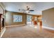 Open-concept living room featuring a ceiling fan, fireplace, sliding glass doors, and seamless transition to the kitchen at 257 Via Franciosa Dr, Henderson, NV 89011