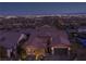 Aerial night view of a well-lit home in a residential area, showcasing the neighborhood and city lights at 294 Besame Ct, Las Vegas, NV 89138
