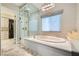 Spa-like bathroom featuring a soaking tub, glass-enclosed shower, and elegant lighting at 294 Besame Ct, Las Vegas, NV 89138