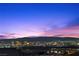 Distant city view and mountains in the evening over rooftops from elevated backyard at 294 Besame Ct, Las Vegas, NV 89138