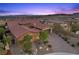 Inviting exterior view of a tan home with desert landscaping, a two-car garage, and a charming brick driveway at 294 Besame Ct, Las Vegas, NV 89138