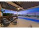 This covered patio features comfortable seating, a fireplace, and a view of the pool and landscape at 294 Besame Ct, Las Vegas, NV 89138
