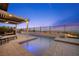 The backyard features an outdoor fireplace, pool, and comfortable lounge seating with amazing views at 294 Besame Ct, Las Vegas, NV 89138