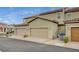 Exterior view of the townhome featuring attached garages and desert landscaping at 3165 Brynley Ave, Henderson, NV 89044