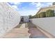 Backyard walkway leading to shed. Stone walls to either side of yard at 3672 Madrid St, Las Vegas, NV 89121