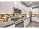 Modern kitchen with stainless steel appliances, white cabinets, tile backsplash, and wood-look flooring at 4273 Sunrise Flats St, Las Vegas, NV 89135