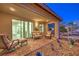 Charming covered patio with brick pavers, desert landscaping, and comfortable seating options at 4273 Sunrise Flats St, Las Vegas, NV 89135