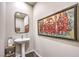 Chic powder room with a pedestal sink, modern mirror, elegant artwork, and stylish fixtures at 4273 Sunrise Flats St, Las Vegas, NV 89135