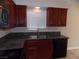 Close-up of the kitchen sink with modern faucet, wood cabinetry and tile floors at 4601 Diamond Head Dr, Las Vegas, NV 89110