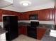 Well-appointed kitchen featuring dark wood cabinetry and black appliances at 4601 Diamond Head Dr, Las Vegas, NV 89110