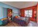 A bedroom with mixed-color painted walls, hardwood floors, and a metal bed frame, filled with vibrant decor at 4730 Mountain Valley Rd, Las Vegas, NV 89121