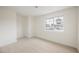This bedroom features neutral carpet, white walls, and a window offering natural light at 4790 E Cleveland Ave, Las Vegas, NV 89104
