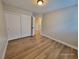 Bright bedroom featuring wood-look flooring and a closet with white sliding doors at 4823 Jubilee Diamond Ct, Las Vegas, NV 89139