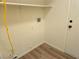 This laundry room offers neutral walls, wood flooring, and a functional shelf for extra storage at 5406 Indigo Hills St, North Las Vegas, NV 89031