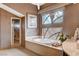 Bathroom with tub and separate shower with glass doors, all decorated in neutral tones at 60 Innisbrook Ave, Las Vegas, NV 89113