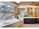 Luxurious bathroom with a soaking tub, custom stained-glass windows, and dual sink vanity at 60 Innisbrook Ave, Las Vegas, NV 89113