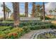 Beautiful Innisbrook community entrance featuring lush greenery, flowerbeds, and mature palm trees at 60 Innisbrook Ave, Las Vegas, NV 89113
