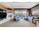 Spacious living room with fireplace, large windows with views, and plush blue seating at 60 Innisbrook Ave, Las Vegas, NV 89113