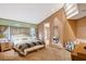 Relaxing main bedroom features a large bed, comfortable armchair, and a decorative mirror at 60 Innisbrook Ave, Las Vegas, NV 89113