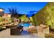 Beautiful outdoor pool area with lounge seating, fire pit and lush landscaping at 60 Innisbrook Ave, Las Vegas, NV 89113