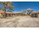 Wide backyard with ample space, featuring a covered patio and mature trees, awaiting your personal touch at 6151 Whispering Sands Dr, Las Vegas, NV 89131