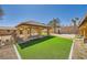 Beautiful backyard featuring a covered patio, green lawn, and mature trees, perfect for outdoor entertaining at 6151 Whispering Sands Dr, Las Vegas, NV 89131