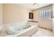 Jetted bathtub for luxury bathing with glass block window providing natural light at 6151 Whispering Sands Dr, Las Vegas, NV 89131