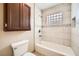 Bathroom showcases a tiled shower-over-tub with glass block window and dark wood storage cabinet at 6151 Whispering Sands Dr, Las Vegas, NV 89131