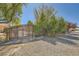 Metal driveway gate is set back from the road between high bushes for privacy at 6151 Whispering Sands Dr, Las Vegas, NV 89131