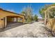 Long driveway leading to a covered carport and home, surrounded by mature landscaping and privacy fencing at 6151 Whispering Sands Dr, Las Vegas, NV 89131