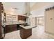 Open kitchen with granite countertops, a large refrigerator, modern appliances, and an island cooktop at 6151 Whispering Sands Dr, Las Vegas, NV 89131