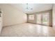 Bright living room with tiled floors, a modern chandelier, and glass doors leading to the backyard at 6151 Whispering Sands Dr, Las Vegas, NV 89131