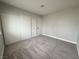 Carpeted bedroom with neutral walls, a sliding door closet, and an adjacent door at 6174 Meadowgrass Ln, Las Vegas, NV 89103